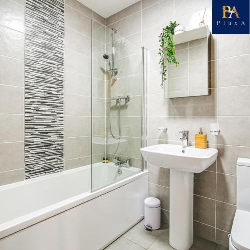 a bathroom with a sink and a tub and a toilet at Pluxa The Hideaway - Fully private serviced apartment & parking in Birmingham