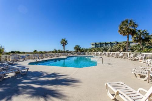a swimming pool with lounge chairs and a resort at Sea Cabin 227-B in Isle of Palms