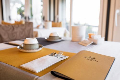 a table with plates and napkins on top of it at Hotel Bellavista in San Zeno di Montagna