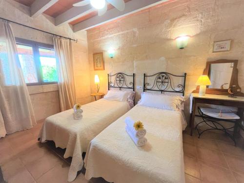 una camera con 2 letti con lenzuola bianche e specchio di Ideal Property Mallorca - Can Rius a Muro