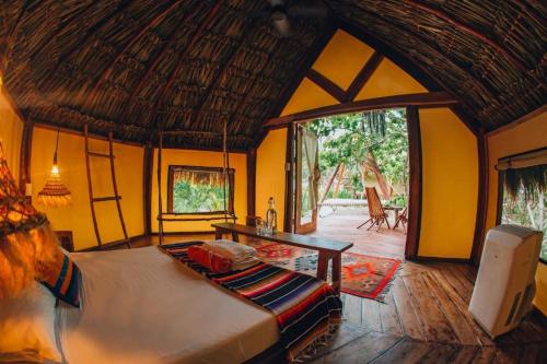 a bedroom with a bed in a room with yellow walls at Ikal Tulum Hotel in Tulum