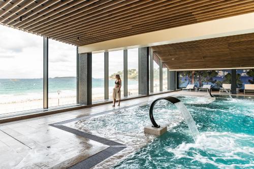 佩羅斯－吉雷克的住宿－Hôtel Roz Marine Thalasso Resort，站在海洋游泳池中的女人