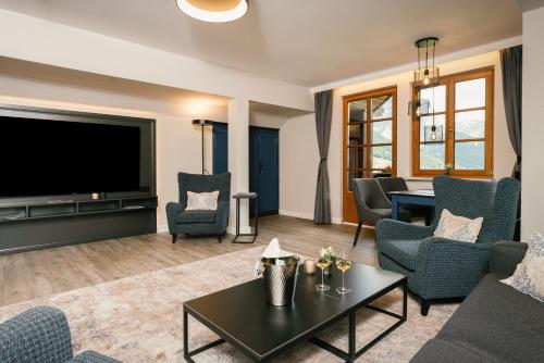 a living room with a large flat screen tv at MONDI Hotel am Grundlsee in Grundlsee