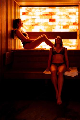 two women in bathing suits sitting on a window sill at Hôtel Roz Marine Thalasso Resort in Perros-Guirec