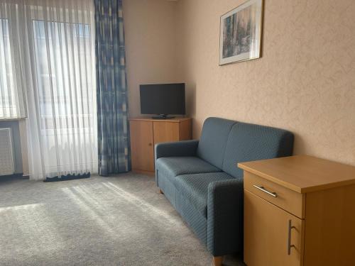 ein Wohnzimmer mit einem blauen Sofa und einem TV in der Unterkunft Haus Tida in Norderney