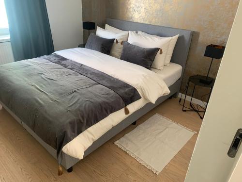 um quarto com uma cama grande e almofadas brancas em Coco's em Antuérpia