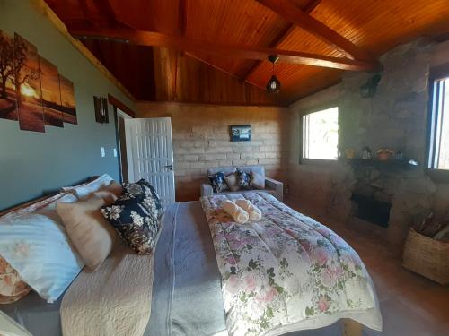 a bedroom with a bed and a stone wall at Cabana do Camelo in São Bento do Sapucaí