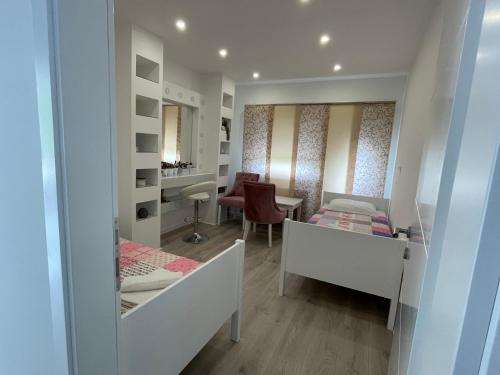Habitación pequeña con 2 camas y escritorio. en Alegro, en Mostar