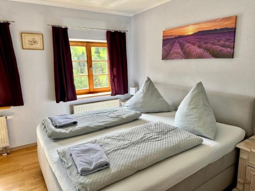 two beds in a room with two windows at Pension Steakhaus Füssen in Füssen