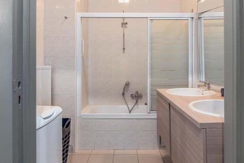 een badkamer met een douche, een bad en een wastafel bij Hera 0101 in Koksijde