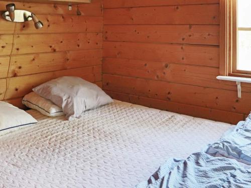 a bedroom with a large bed in a wooden room at 5 person holiday home in Båstad-By Traum in Båstad