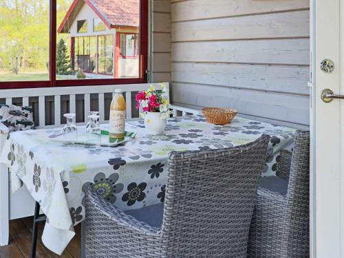 a table with a white table cloth and chairs on a porch at 5 person holiday home in Båstad-By Traum in Båstad