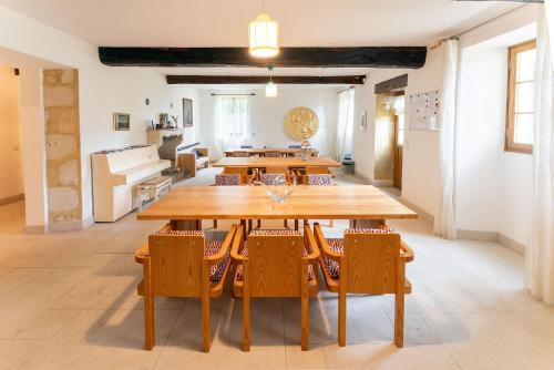 une salle à manger avec une grande table et des chaises en bois dans l'établissement Château Marteret, à Vic-Fezensac