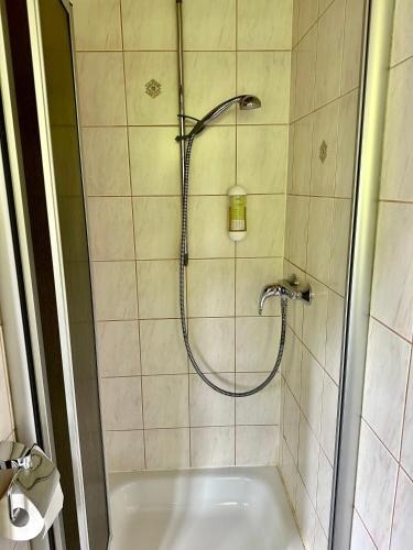 a bathroom with a shower with a bath tub at Pension Steakhaus Füssen in Füssen
