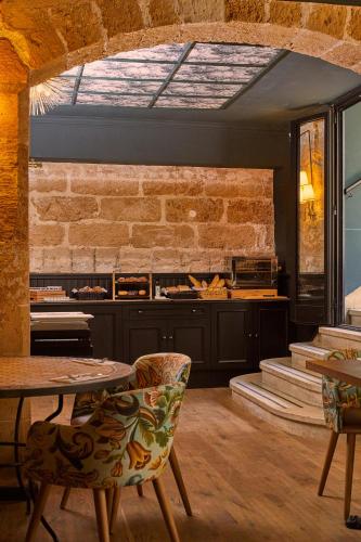a kitchen with a table and chairs and a brick wall at Hotel Born in Palma de Mallorca