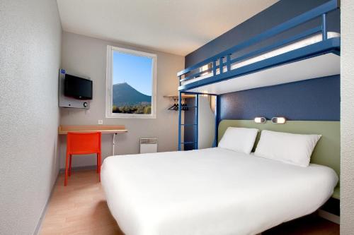 ibis budget Clermont Ferrand Nord Riom في ريوم: غرفة نوم مع سرير وسرير بطابقين