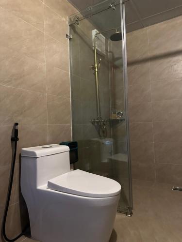a bathroom with a toilet and a glass shower at Bac Ha Lodge Retreat in Bắc Hà