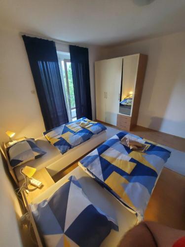 1 dormitorio con 2 camas y un espejo grande en Apartman Benat en Stolac