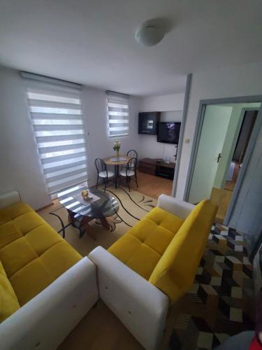 uma sala de estar com um sofá e uma mesa em Apartman Benat em Stolac