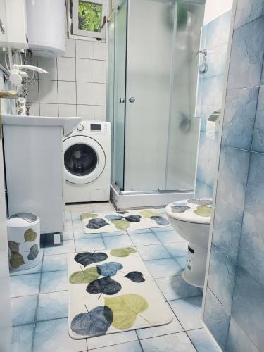 Un baño con lavadora y un inodoro. en Apartman Benat, en Stolac