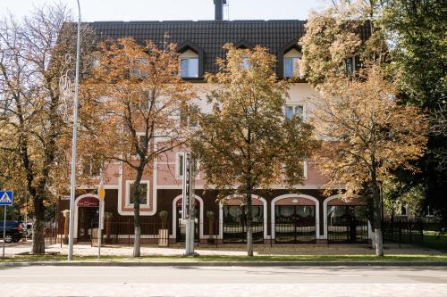 um edifício numa rua com árvores em frente em Non-stop hotel em Boryspil