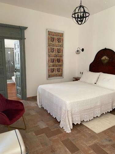 a bedroom with a white bed and a red chair at Dimora Ferraris in Càbras