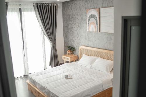 1 dormitorio con 1 cama grande con sábanas blancas en C.House - Villa Homestay Long Hải en Ấp Lò Vôi