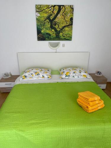 a green bed with two towels on top of it at Đana in Cres