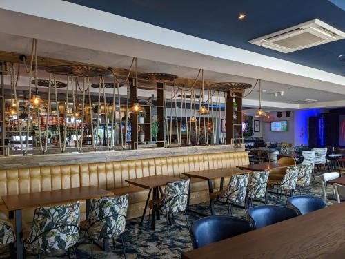 a bar in a restaurant with wooden tables and chairs at Chichester Lakeside Self-Catering Holiday Home in Chichester