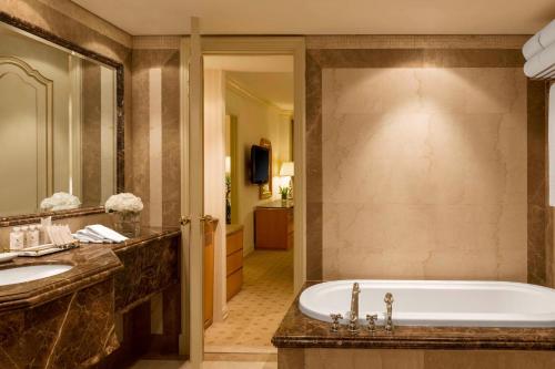 a bathroom with a tub and a sink at Sheraton Kuwait, a Luxury Collection Hotel, Kuwait City in Kuwait