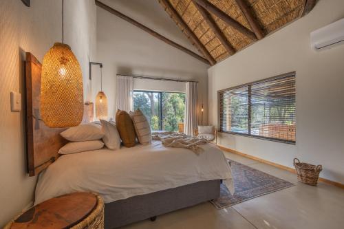 a bedroom with a bed and a large window at Ukanyi Luxury Villa in Hoedspruit