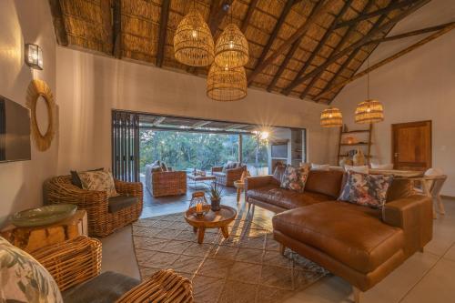 a living room with a couch and a table at Ukanyi Luxury Villa in Hoedspruit