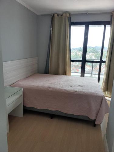 1 dormitorio con cama y ventana grande en Ocean View Residence, en Natal
