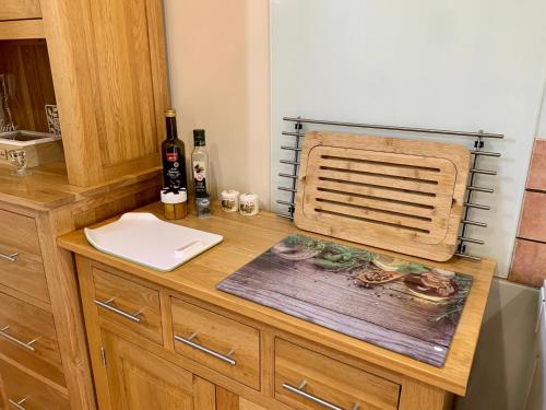 a kitchen counter with a sink and a bottle of wine at Le Bas Chesnay Gîte Domfront en Poiraie in Domfront