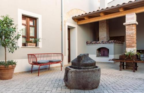 eine Steinstatue und eine Bank im Innenhof in der Unterkunft Dimora Ferraris in Càbras