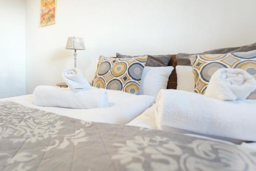 a bedroom with two beds with pillows and a couch at Cocoon am Schloß in Lochau