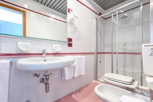 La salle de bains est pourvue d'un lavabo et de toilettes. dans l'établissement Hotel Aurora, à Desenzano del Garda