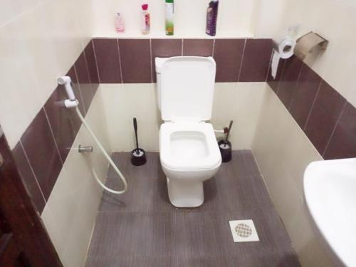 a small bathroom with a toilet and a sink at Homestay Luxurious apartments with swimming pool in Mtwapa