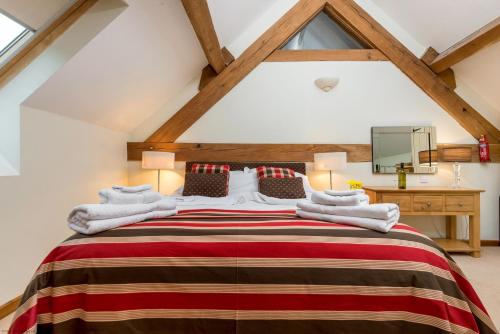 a bedroom with a large bed in a attic at Orchard Barn in Little Dean
