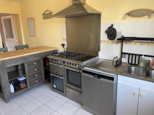 une cuisine avec une cuisinière et un évier dans l'établissement Vendée - Petite Maison de Vacances, à La Genétouze