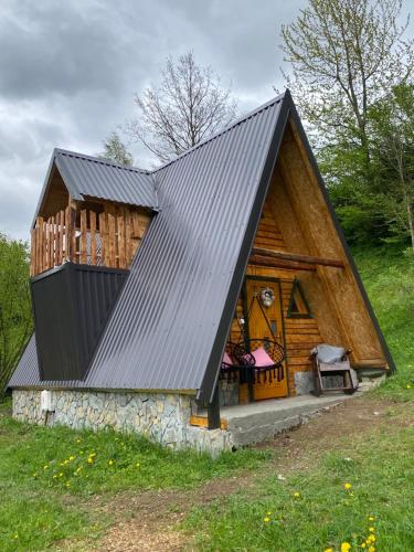 una cabaña de madera con un gran techo de gambrel en Eco kutak 2 en Mojkovac