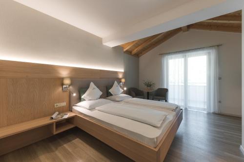 a bedroom with a large bed and a large window at Untermairhof in Lagundo