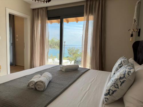een slaapkamer met een bed met handdoeken en een raam bij Life's Moments in Limenaria