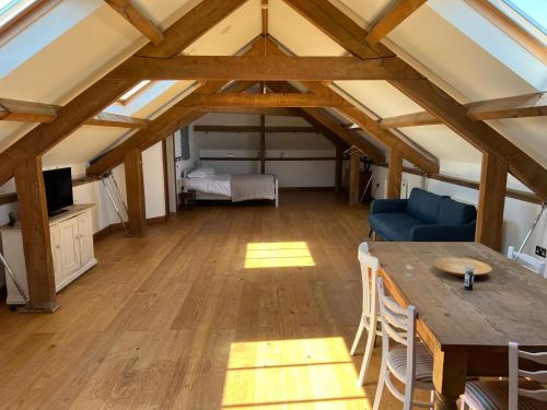 a room with a table and a couch and a bed at The Old Stable Block - Flat 2 in Wadebridge