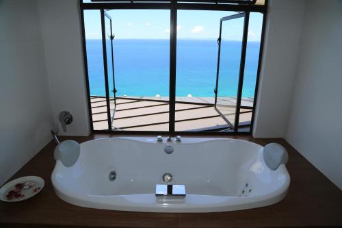 a bath tub with a view of the ocean at La Vue in Beau Vallon