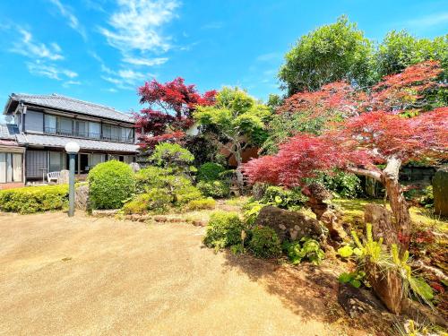 a garden in front of a house with colorful trees at Iriyama-So in Shimoda