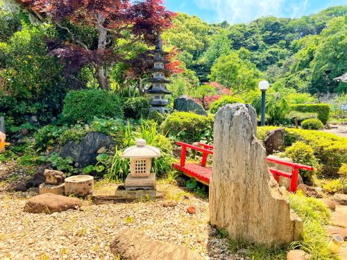 a garden with a red bench and a lantern at Iriyama-So in Shimoda
