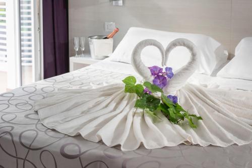 two swans in a wedding dress sitting on a bed at Hotel La Pineta in Follonica