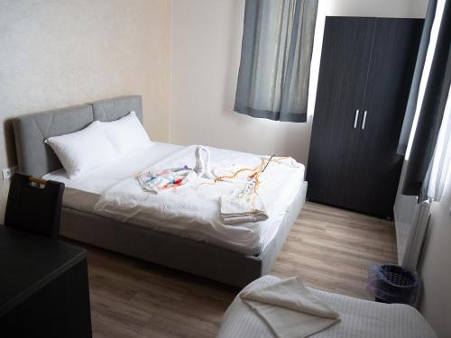 Un dormitorio con una cama con ropa. en Hotel Rezime, en Zenica