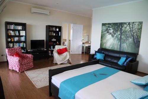 a bedroom with a large bed and a living room at La Vue in Beau Vallon